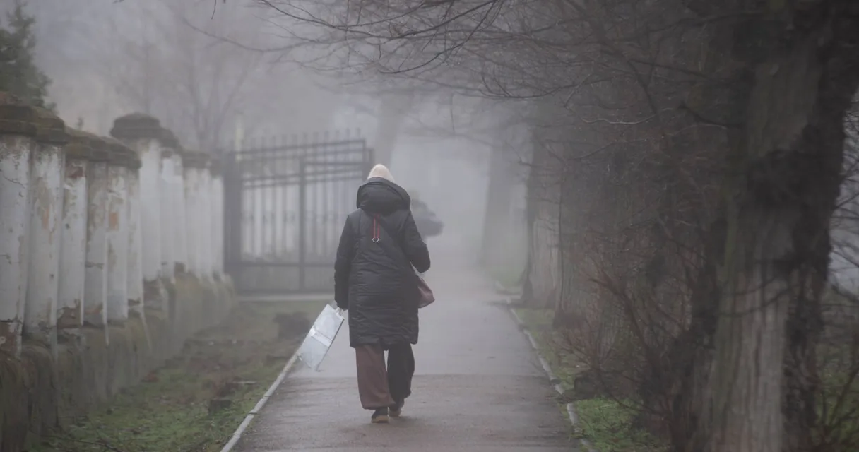 Corredor caminhando sob neblina numa manhã fria de inverno